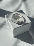 Selenite silver plated ring with a geometric white stone on a textured white jewelry box in Florida 