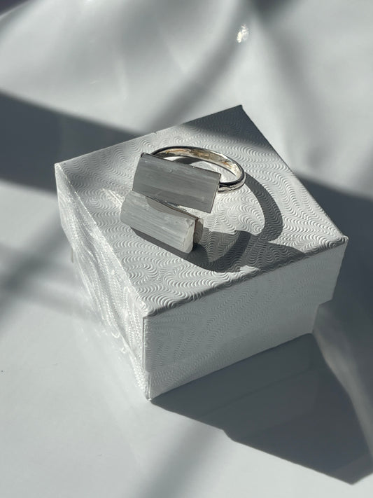 Selenite silver plated ring with a geometric white stone on a textured white jewelry box in Florida 