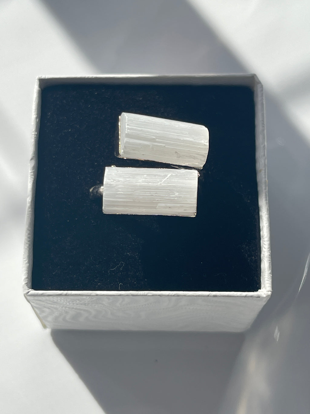 selenite ring silver plated inside a black and white jewelry box in Florid studio by pure energy crystals