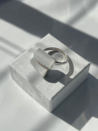 Selenite silver plated ring on a textured white jewelry box top in Florida studio 