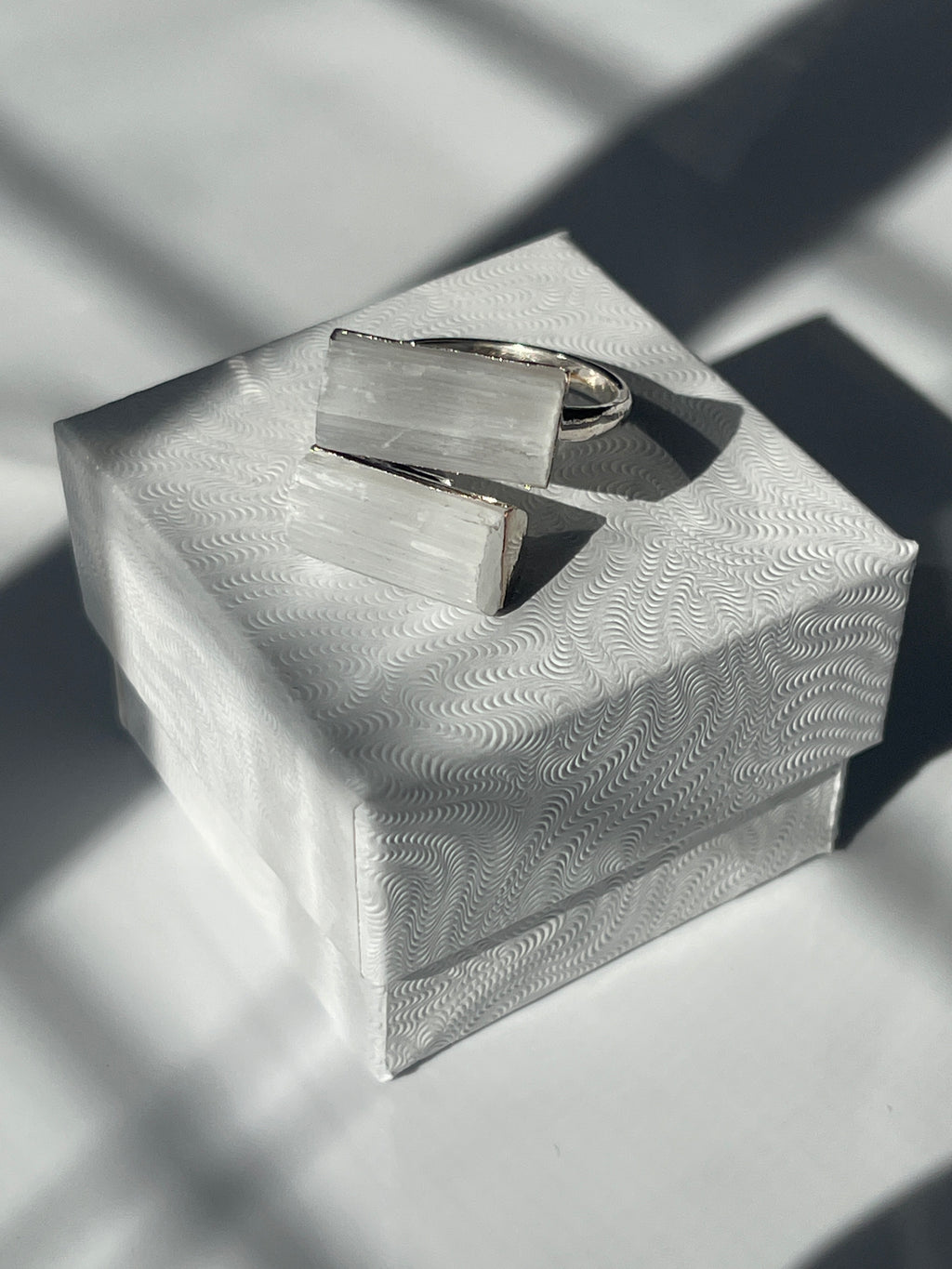 Selenite silver plated adjustable ring on top of a jewelry box
