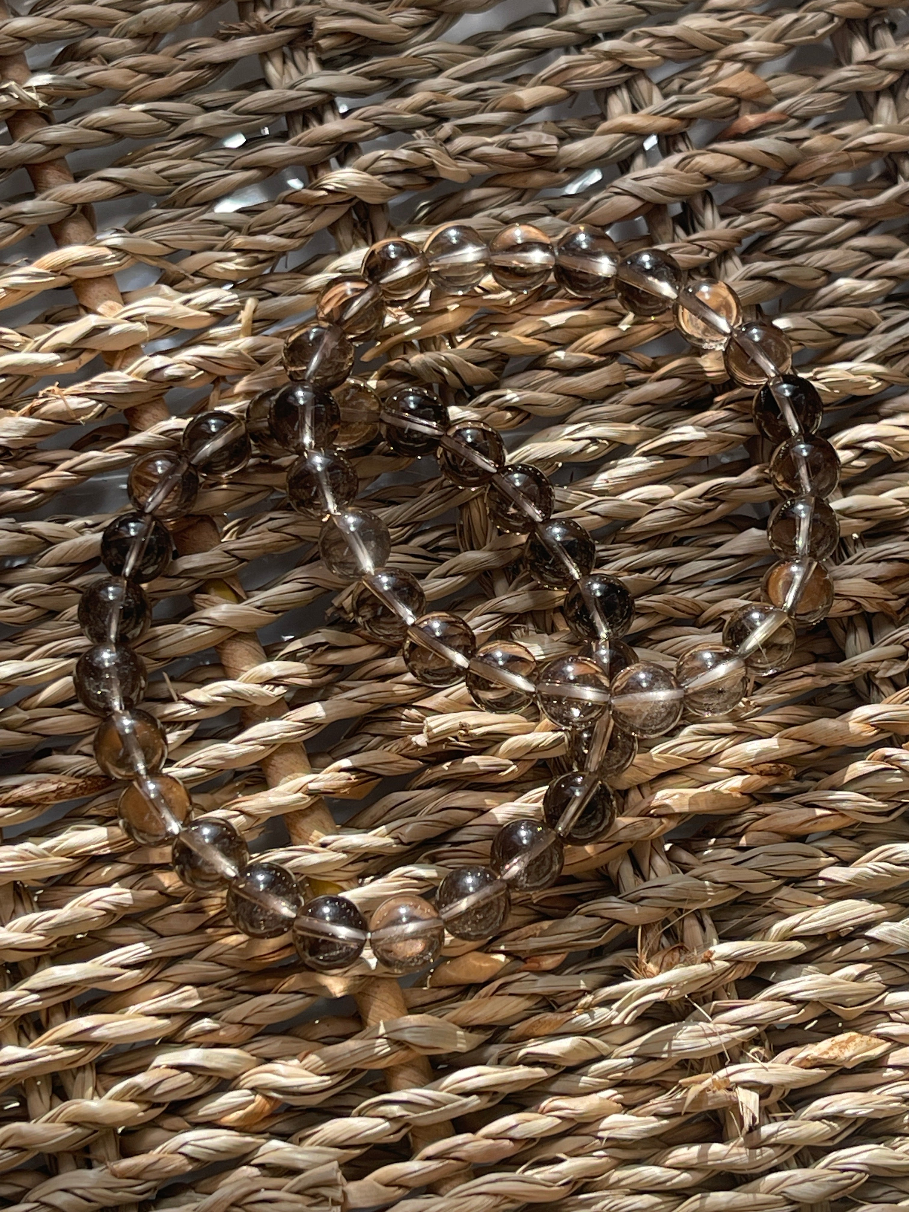 Smoky Quartz Beaded bracelet on a woven straw surface