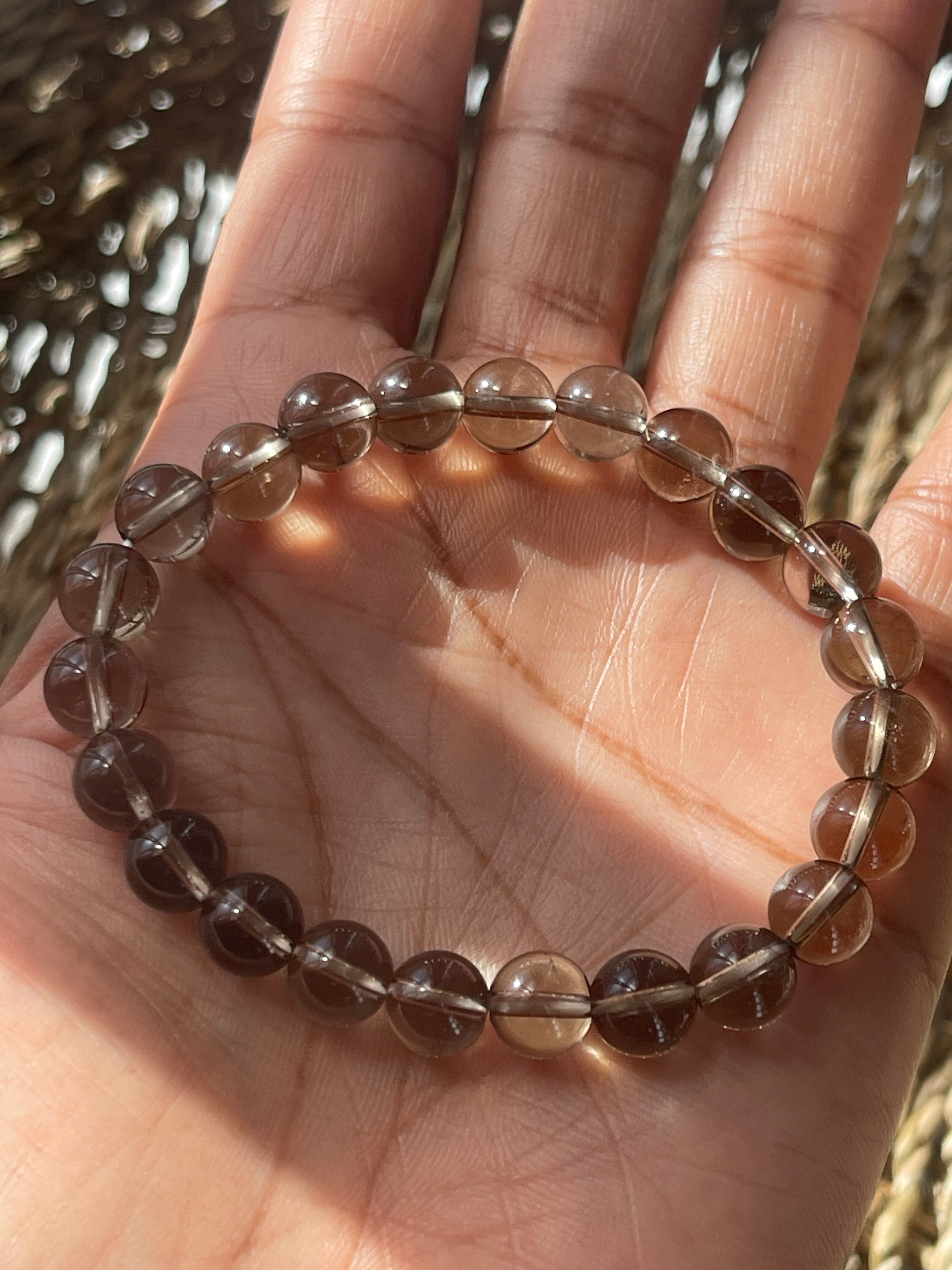 Smoky Quartz Beaded bracelet on a hand with a blurred background