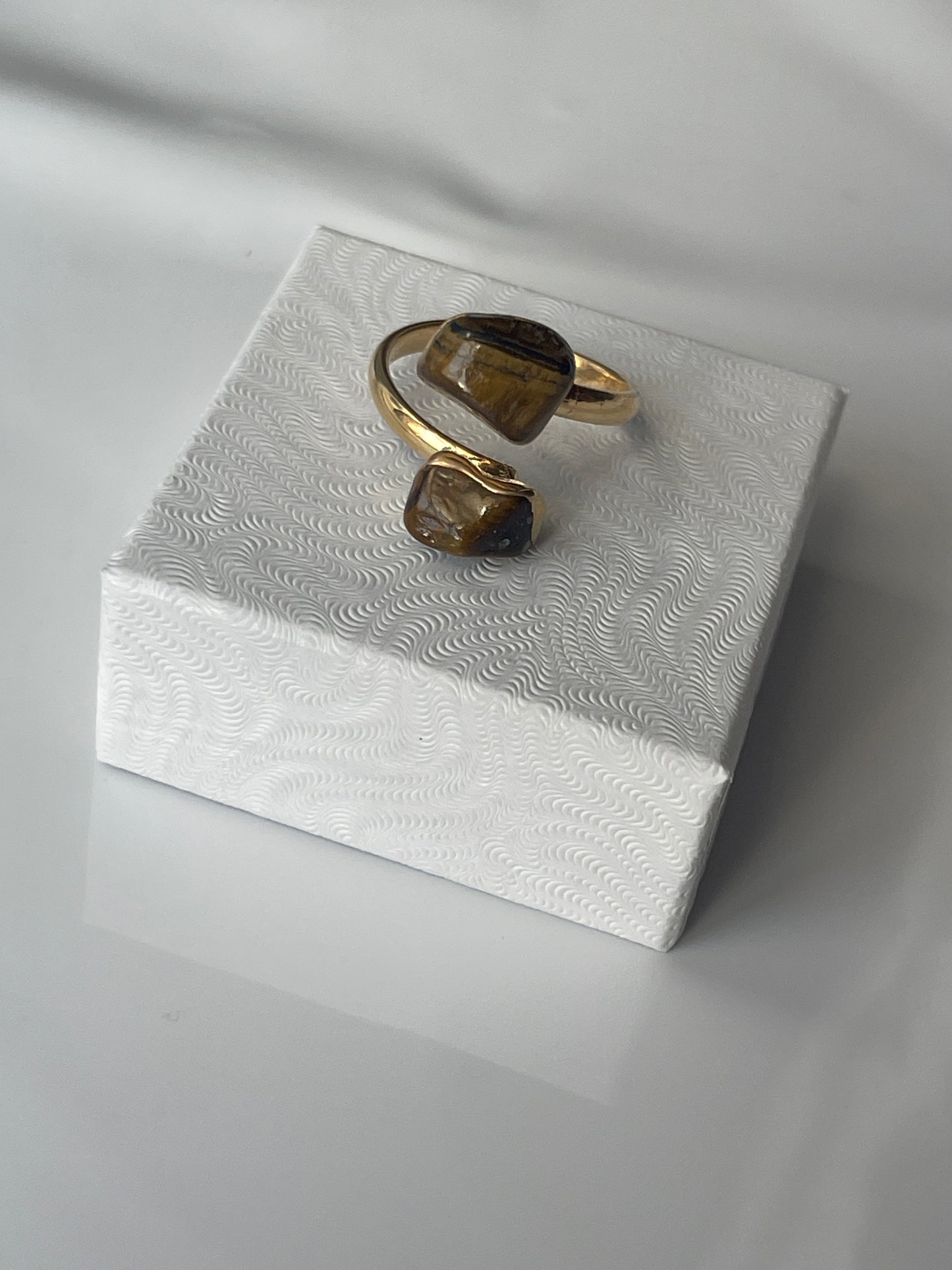 Tigers eye gold plated ring on a textured white jewelry box top in Florida 