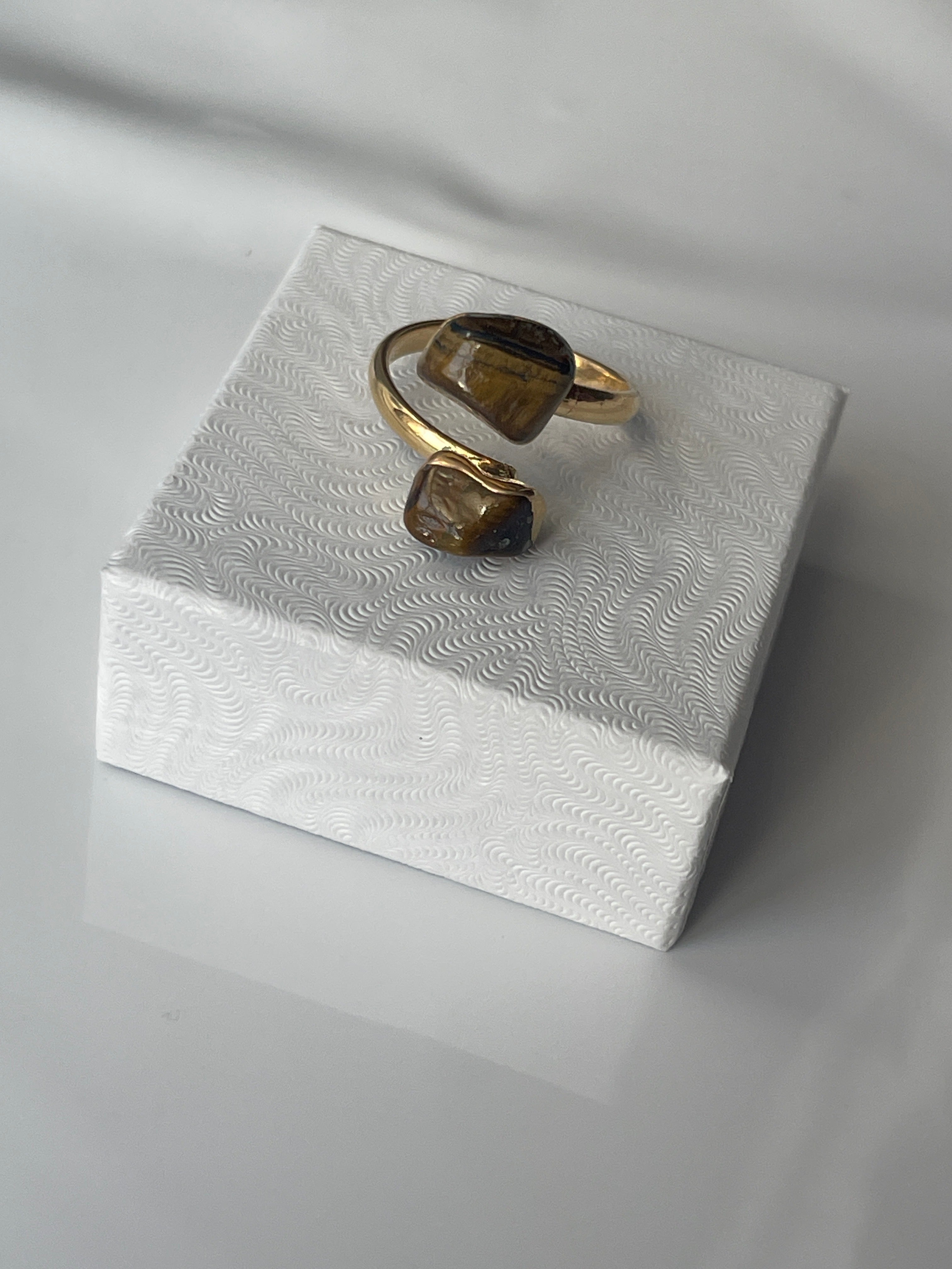 Tigers eye gold plated ring on a textured white jewelry box top in Florida 