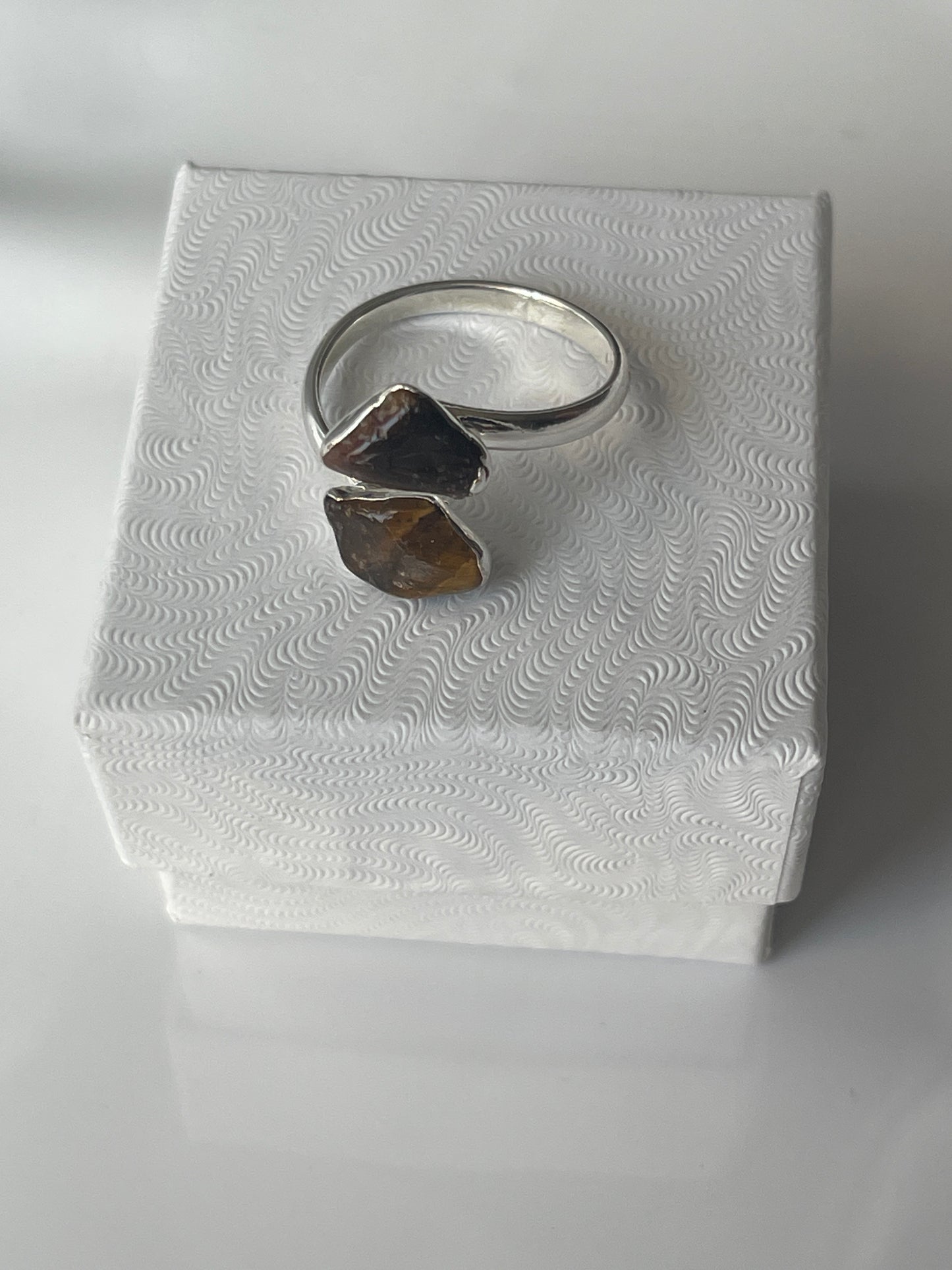 Tigers eye silver plated ring on a textured white jewelry box in Florida 