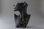 Black jewelry display with Tigers_Eye_Chip_Necklace_30-32_Inches on a gray studio background 