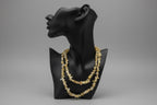 Black jewelry holder display with a Yellow_Opal_Necklace_30-32_Inches on a gray backdrop studio surface 