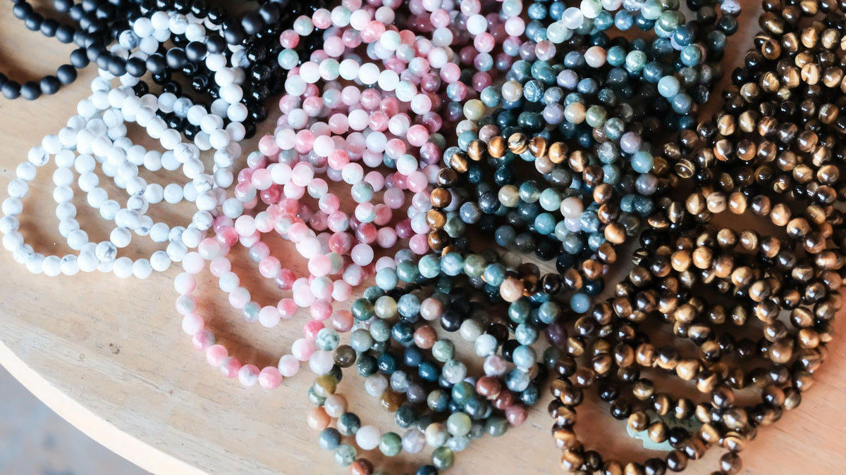 Collection of beaded bracelets in various colors on a wooden surface at pure energy crystals